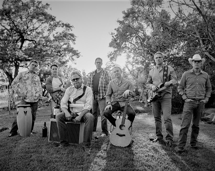 black and white image of the Silverado Pickups band standing in an outdoor clearing with their instruments