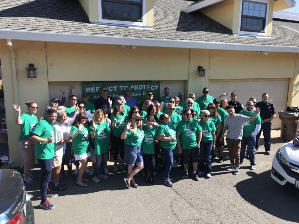 group of Volunteers in green t-shirts smiling