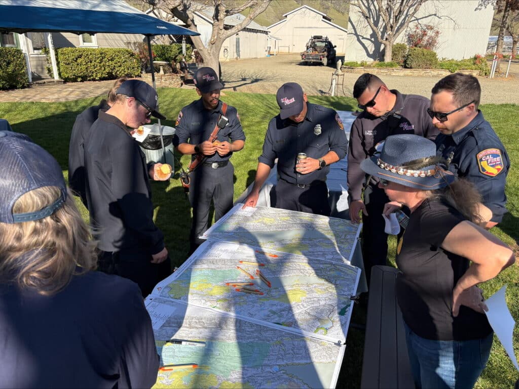CAL FIRE staff looking over a map spread out on a table