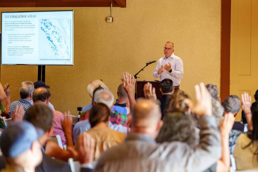 man at a podium speaking to a crowd